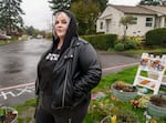 Allie Bradley looks over a memorial for June “T-Rex” Knightly, at the corner of Northeast Hassalo Street and Northeast 55th Avenue in Portland, April 10, 2023. Bradley was shot four times at a protest a year prior.