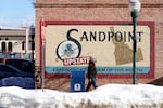 A pedestrian walks past a mural, Monday, Feb. 7, 2022, in downtown Sandpoint, Idaho. The Mayor of Sandpoint and many residents worry that the trend of a growing number of real estate companies advertising to conservatives that they can help people move out of liberal bastions like Seattle and San Francisco and find homes in places like rural Idaho is not good for their community.