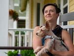 Peyton Scott in her home in Astoria, Ore., holding dog Chiara, Aug 11, 2024. Scott lives in a multigenerational home with her mother and grandmother. 