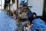 Tim Varner, 57, uses blankets to stay warm in the snow as he huddles with his belongings in a storefront in Portland, Ore. on Friday, Feb. 24, 2023. The thousands of people living on Portland's streets have struggled to stay warm after a storm on Wednesday dumped nearly a foot of snow, resulting in the city's second snowiest day on record.