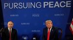 Russian President Vladimir Putin and President Trump are seated side by side before the start of talks in Anchorage, Alaska. A blue backdrop behind them says "PURSUING PEACE" at the top.