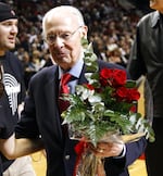 Portland Trail Blazers founding broadcaster Bill Schonely walks off the court with roses.