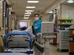 Monica Sanchez Coria cares for a patient in the hallway of the Salem Health emergency department in Salem, Ore., in January. The department has 53 patient rooms but made space for 100 by adding hallway beds to handle the influx of people seeking treatment.