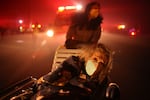 Tuesday, Jan. 7: A resident of a senior center is evacuated as the Eaton Fire approaches in Altadena, Calif.
