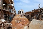 People check an area damaged by flash floods in Derna, eastern Libya, on Monday.