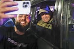 Yevgeny Prigozhin, the owner of the Wagner Group military company, right, sits inside a military vehicle posing for a selfie photo with a local civilian on a street in Rostov-on-Don, Russia, on Saturday.