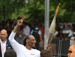Snoop Dogg carries the Olympic torch at the 2024 Summer Olympics, Friday, July 26, in Saint-Denis, outside Paris, France.