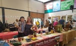 Brandy Collier works the Eugene Area Gleaners booth at an undated sustainability event in Eugene, Ore.