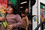 (from left) Rosa, Angel and Sinforosa leave with their bouquets of cempasúchil purchased from Colima Market in Bend, Ore., on Oct. 30, 2024.