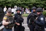 Private citizens acting as crowd control for the pro-Trump rally at Terry Schrunk Plaza Sunday, June 4, 2017, identified themselves via yellow stripes on their shoulders and backs. Law enforcement agencies have come under fire for collaborating with these citizens, some of whom are known-members of militia style groups such as the Oath Keepers and Three Percenters.