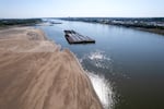 FILE - Barges float in the Mississippi River as a portion of the riverbed is exposed, on Sept. 15, 2023, in St. Louis. The U.N. weather agency is reporting that 2023 was the driest year in more than three decades for the world's rivers, as the record-hot year underpinned a drying up of water flows and contributed to prolonged droughts in some places.