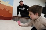 Milo Morris, age 3, plays while his dad, Portland State University student Tyson Morris, watches at an indoor playground DiG PDX in Portland, Ore. on Thursday, Nov. 6, 2025. Morris is a returning college student who works part-time and relies on SNAP benefits to pay for the family's food.