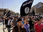 Demonstrators chant pro-Islamic State group slogans as they carry the group's flags in front of the provincial government headquarters in Mosul, Iraq, on June 16, 2014.