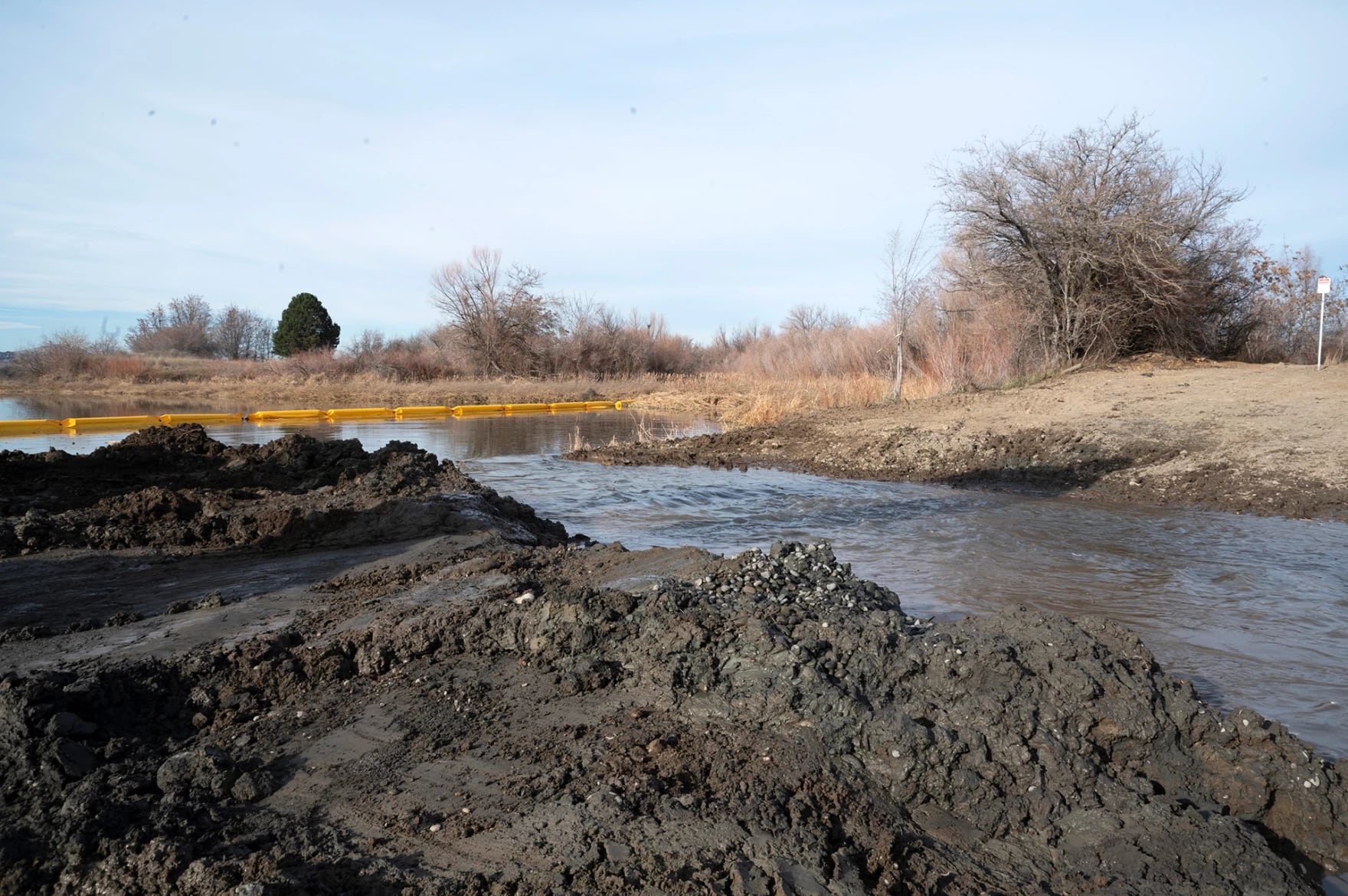 Water flows through a small slice between Bateman Island and a land bridge, which led to the island. Crews are expected to continue to work on the removal project through mid-February.