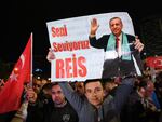 A supporter of Turkish President Tayyip Erdogan holds a poster which reads "We Love You Chief" outside the AK Party headquarters after polls closed in Turkey's presidential and parliamentary elections in Ankara, Turkey on Monday.