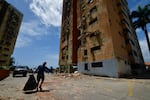 A man walks past a building damaged by earthquakes that struck Puerto Cabello, Venezuela, a day earlier, Thursday, June 25, 2026.