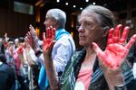 Protesters with palms painted red to resembles blood, hold their hands up during the Senate Homeland Security and Governmental Affairs Subcommittee on Investigations hearing to examine Boeing's safety, on Capitol Hill, Tuesday, June 18, 2024, in Washington.