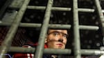 Alexei Navalny is seen in 2012 behind the bars in a police van after he was detained during protests in Moscow a day after Putin's inauguration.