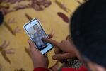 Said Mohammad Mustapha looks at pictures of his 15-year-old daughter, Zaynib, on his phone. He and his wife lost contact with Zaynib.