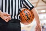 A referee holds the ball in the quarterfinals of the OSAA 6A Boys Basketball Championships between Grant High School and West Salem High School at the Chiles Center in Portland, Oregon, Thursday, March 8, 2018.