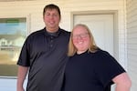 Cook employees Ryan and Shelby Bixler stand in front of the house they're buying from the company. They say they never could have afforded a new place like this at the full market price.