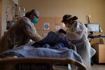 In this Dec. 22, 2020, file photo, registered nurses Robin Gooding, left, and Johanna Ortiz treat a COVID-19 patient at Providence Holy Cross Medical Center in the Mission Hills section of Los Angeles. Coronavirus deaths in the U.S. hit another one-day high on Tuesday, Jan. 12, 2021, at over 4,300 with the country’s attention focused largely on the fallout from the deadly uprising at the Capitol.