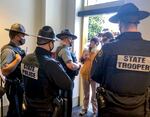 Members of a group protesting mask requirements at the Oregon Capitol in Salem try to get access to the building, in February. State police are waiting and turning the maskless away.