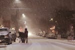 People roll a giant snowball across Southeast 13th Avenue in Portland's Sellwood neighborhood on Tuesday, Jan. 10, 2017.