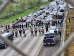 Protesters stand on Interstate 5 in Eugene, some with Palestinian flags, closing the southbound lanes between Eugene and Springfield around 10 a.m., April 15, 2024. According to KEZI, law enforcement on the scene arrested about 50 people, and the freeway was open again around 11 a.m.