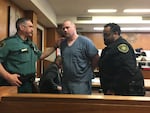 Officers escort Jeremy Christian, the man accused of stabbing and killing two people on a TriMet light rail train in 2017, out of the courtroom Friday, April 26, 2019, at the Multnomah County Courthouse in Portland, Ore.