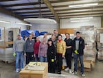Yulia Brockdorf is the co-founder and president of DAWN, a nonprofit that has been providing humanitarian aid to Ukraine. Brockdorf is shown in this photo wearing a gray vest and black pants, posing with volunteers from DAWN in February 2024 as they prepared pallets of medical supplies to send to Ukraine.
