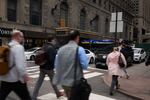 People walk past the Roosevelt Hotel, which has been converted to the main processing center for migrants arriving to New York City.