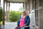 Susan Campbell, a local historian, sits on the front porch of Fendall Hall. She says she'd like to see more information about the Young-Dent family included on the historical marker at the mansion.