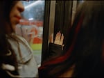 A woman places her hand on the metro car sliding door in December 2023.
