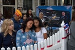 Family of Sgt. Angel Sarah Rampersad, aunt Judy Rackal, left, mother Carol Acevedo, center, and sister Laura Tamby, right, attend a candlelight vigil outside her home in Ozone Park, Monday, July 27, 2026, in the Queens borough of New York.