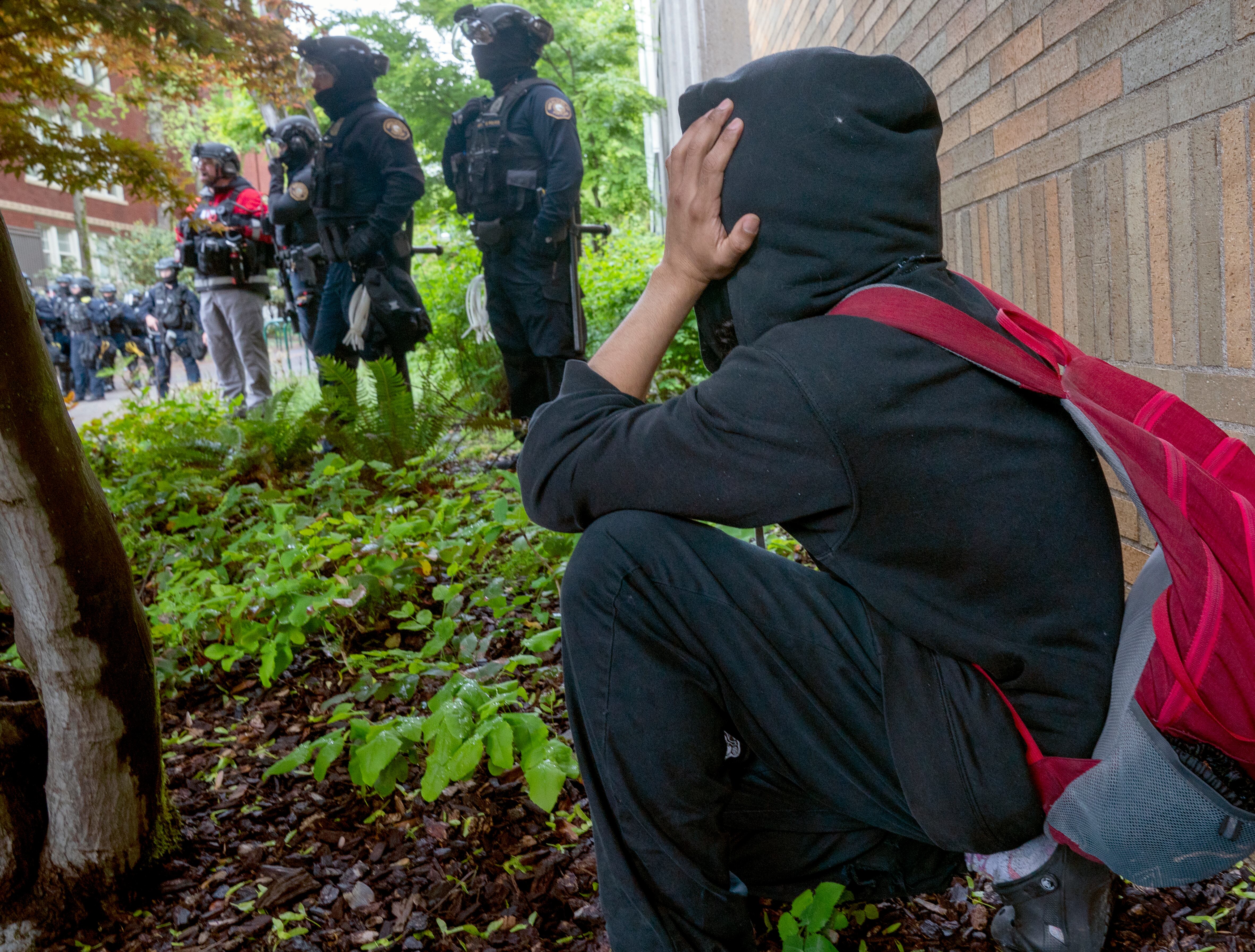 A young person watches the events unfold law enforcement teams clear protesters from Portland State University’s Branford Price Millar Library, May 2, 2024. People protesting Israel's role in the war in Gaza had occupied the library since Monday evening.