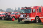 A firefighter rests on the bumper of a truck at a fire camp in Hood River.