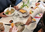 Customers pass around dishes at Tan Tan Café and Delicatessen in Beaverton, Ore., June 13, 2025. Tan Tan has offered Southern Vietnamese products and dishes for over two decades.