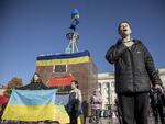 Civilians carrying Ukrainian flags celebrate the withdrawal of the Russian army at Independence Square in Kherson on Monday.