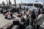 Palestinians holding foreign passports collect their luggage as they prepare to cross to Egypt from the Gaza Strip through the Rafah border crossing on Feb. 6.