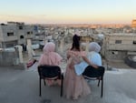 Three sisters sit looking out over a sea of debris as the sun sets in northern Gaza's militarized orange zone of Beit Lahia, on May 31.