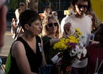 Patricia Schechter, PSU professor and chair of the Jason Erik Washington Art Committee, holds a vase for community members to place flowers into Thursday, June 29, 2023.