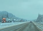 In this photo provided by ODOT, a long line of 18-wheelers clogs the northbound lanes of Interstate 5 near Creswell, Oregon. Lane County was hit particularly hard by the recent winter storms, with snow and ice leading to road closures, downed trees and extensive power outages.