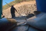 Tribal fishermen at Lyle Falls wear a rope around the waist to catch them in case they fall off the fishing platform.