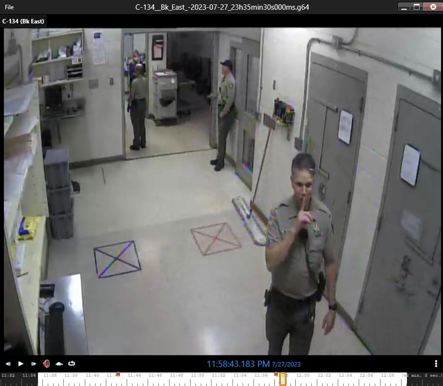 Sgt. Matt Savage puts his finger to his lips in a shushing gesture after deputy Jeanamarie Fisher re-enacted the altercation with Anton Williams.
