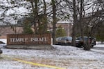 Police vehicles sit outside the Temple Israel synagogue Friday, March 13, 2026, in West Bloomfield Township, Mich.