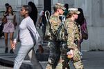 National Guard personnel keep watch as travelers arrive at the entrance to Union Station near the Capitol, in Washington, D.C., on Thursday, Aug. 14, 2025.