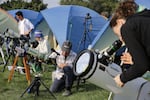 Umbraphiles and photographers prep their telescopes and cameras while they await the eclipse in Madras.
