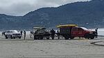 Several rescue vehicles and personnel involved in a beach rescue