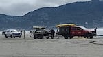 Several rescue vehicles and personnel involved in a beach rescue